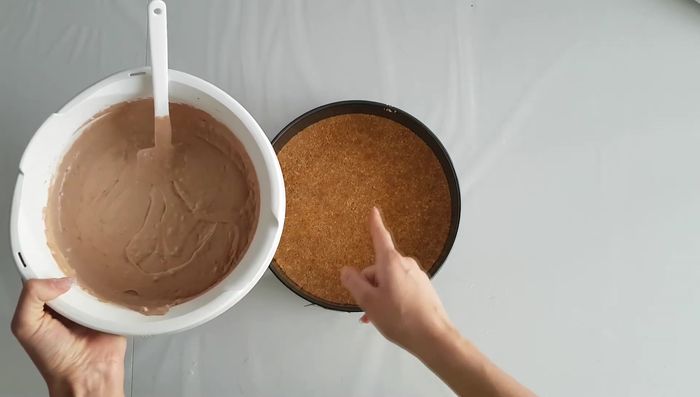 Die Füllung auf den vorbereiteten Keksboden geben.
