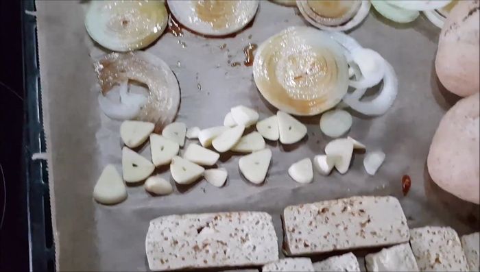 Knoblauch und Zwiebeln schneiden und auf den Tofu geben. Mit etwas Sojasauce beträufeln.