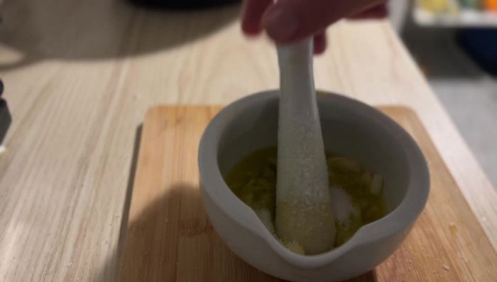 Pfeffer, Tamarinde, Tomatenmark und Kreuzkümmel zur Knoblauchmischung geben.
