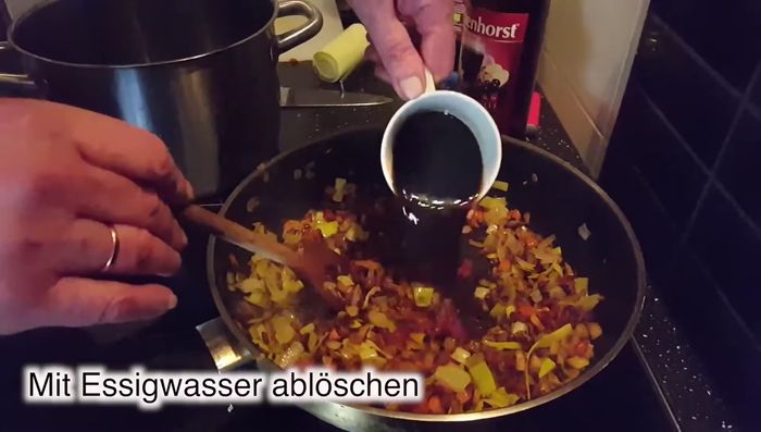 Mit Essig-Wasser-Mischung ablöschen und 5 Minuten köcheln lassen, bis die Flüssigkeit verdampft ist.