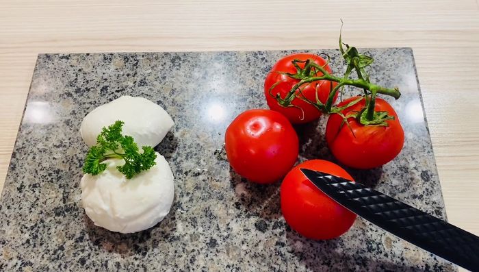 Tomaten und Mozzarella in Scheiben schneiden.