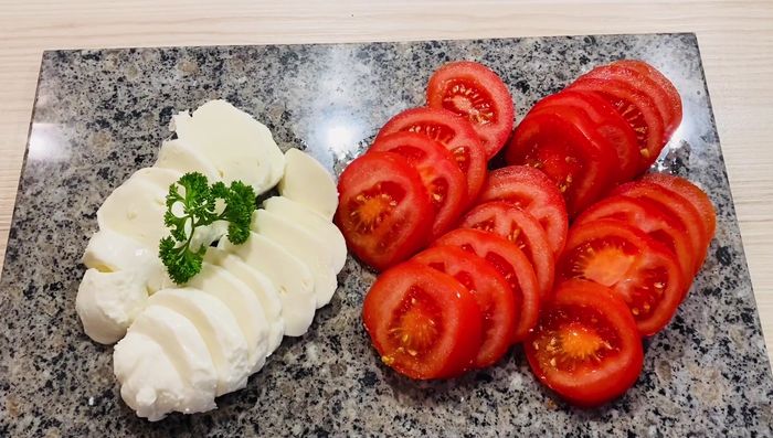 Fleisch aus dem Kühlschrank nehmen und in eine Auflaufform geben. Tomaten und Mozzarella in das Fleisch legen.