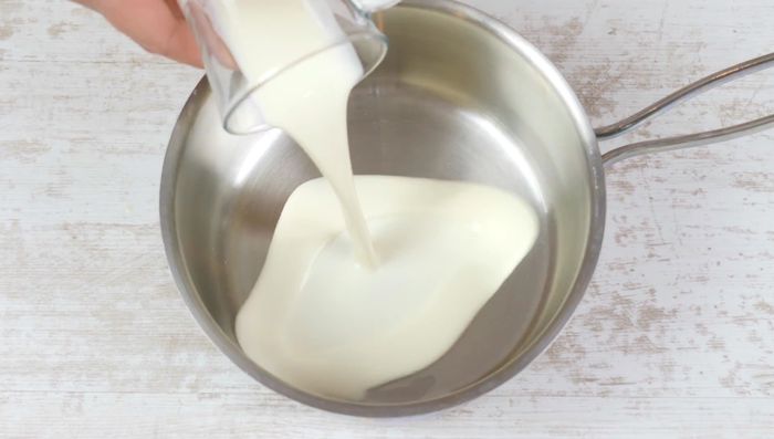 Milch, Sahne und Zucker in einem Topf zum Kochen bringen.