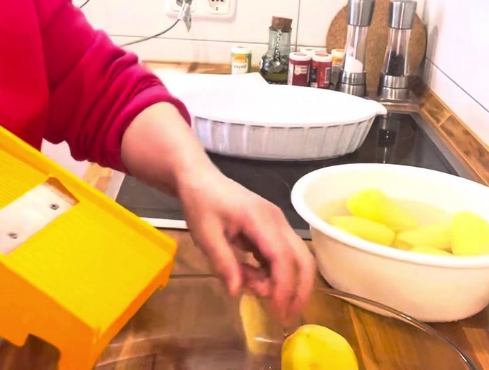 Kartoffeln schälen und mit einer Reibe dünn raspeln. Vorsicht beim Reiben!