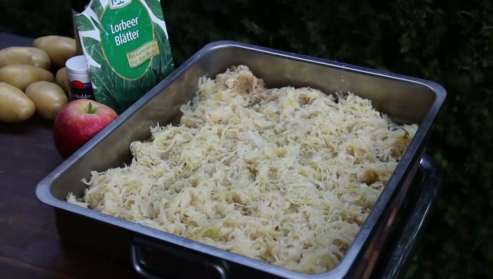 Sauerkraut in die Konservendose geben und mit Wacholderbeeren, Lorbeerblättern und in kleine Stücke geschnittenem Apfel vermischen (149.16).