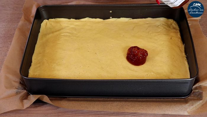 Nussfüllung vorbereiten: Gehackte und gemahlene Haselnüsse, Butter, Zucker und Wasser in einer Pfanne aufkochen und köcheln lassen, bis eine feuchte Masse entsteht.