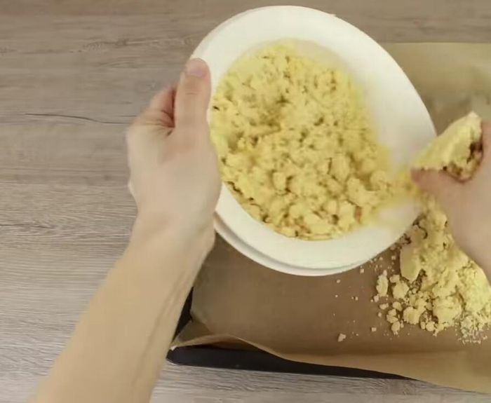 Backblech mit Backpapier auslegen. Die Hälfte des Teigs darauf verteilen und dünn ausrollen.