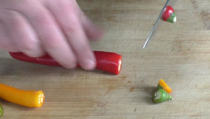 Chilischoten köpfen, längs aufschneiden.