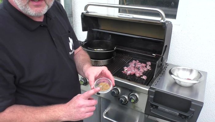 Kumin, Koriander, Salz und Pfeffer zu den Zwiebeln geben.