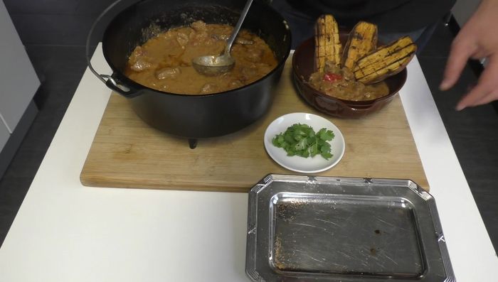 Lammragout und Süßkartoffeln anrichten, mit Korianderkraut garnieren.