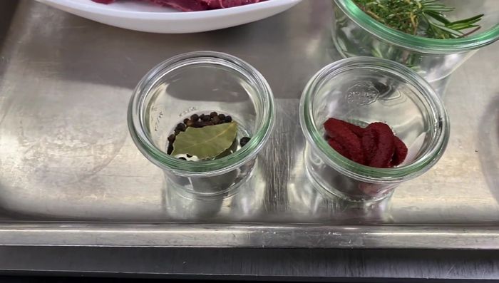 Tomatenmark, Gewürze, Wacholderbeeren, Rotwein hinzufügen. Mit Salz abschmecken.
