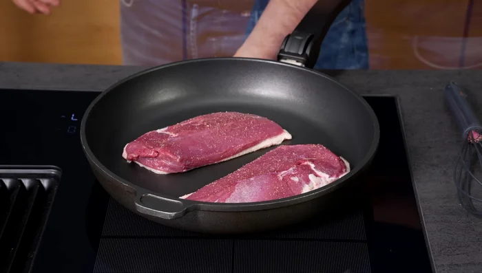 Entenbrust in eine kalte Pfanne legen und erhitzen. Das Fett aus der Haut auslassen lassen.