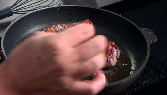 Das ausgelassene Entenfett mit Knoblauch und Thymian aromatisieren. Die Ente mit dem Fett übergießen (Arrosieren).