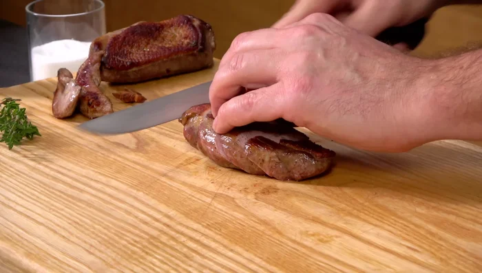 Ente schräg tranchieren und mit der Soße servieren.