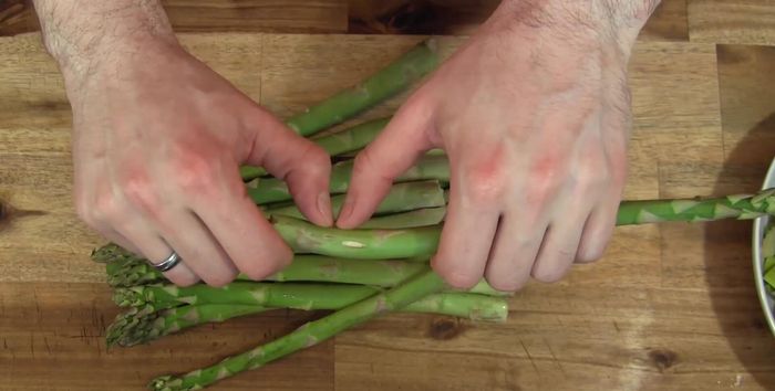 Grünen Spargel an der Bruchstelle brechen, die holzigen Enden entfernen und in Stücke schneiden. Die Spargelköpfe beiseite stellen (300.52).