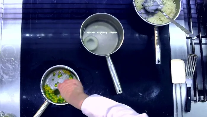 Gemüsefüllung (Mais und Erbsen) anschwitzen, Salz, Pfeffer und Knoblauch hinzufügen.