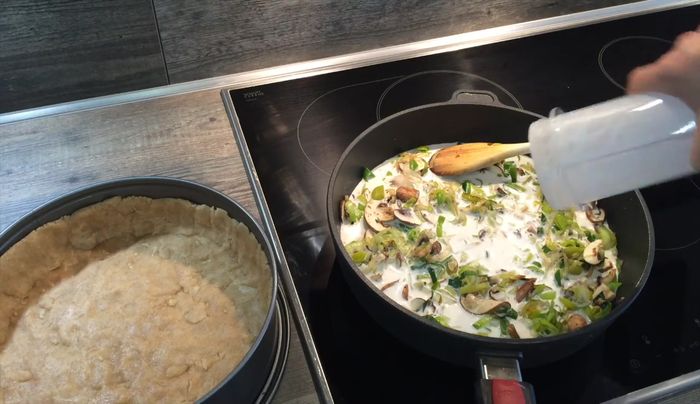 Cashew-Sahne über den Teig gießen. Lauch-Champignon-Mischung darauf verteilen.