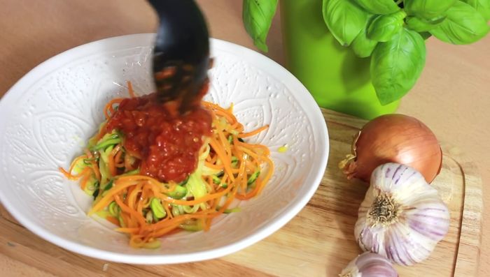 Spaghetti auf Teller geben, Tomatensoße darüber geben, Feta-Käse (optional) darüber bröseln und mit Basilikum garnieren.
