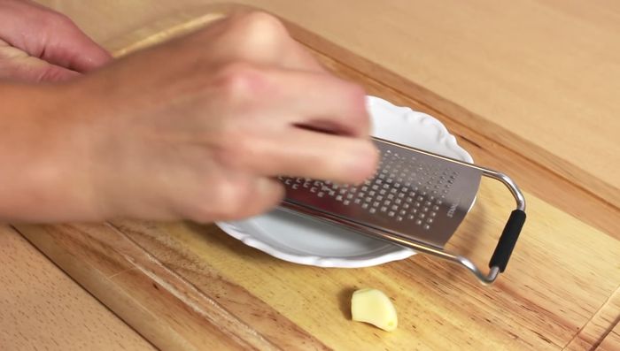 Knoblauch reiben und Zwiebel in kleine Würfel schneiden.