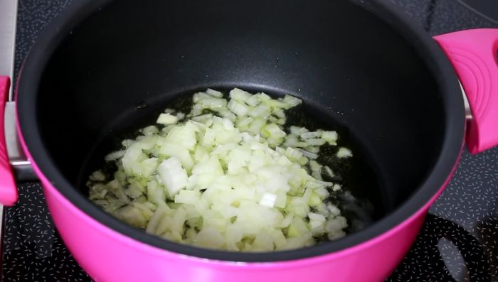 Olivenöl in einen Topf geben, Zwiebeln anbraten, Knoblauch hinzufügen und vermischen.