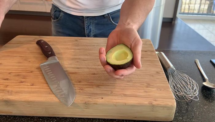 Avocado halbieren, das Fruchtfleisch herauslösen und in Scheiben schneiden.