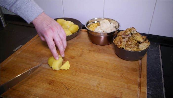 Kartoffeln und Blumenkohl in mundgerechte Stücke schneiden.