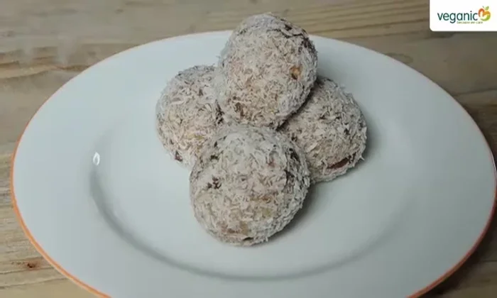 Kokosraspeln in eine Schüssel geben und die Kugeln darin wenden, bis sie vollständig bedeckt sind.