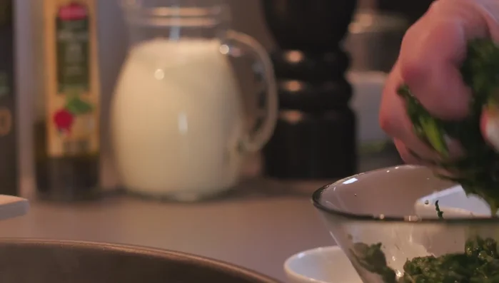 Spinat ausdrücken, in die Pfanne geben und 2 Minuten dünsten.