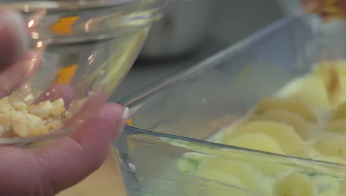 Mit gehackten Nüssen und geriebenem Käse bestreuen.