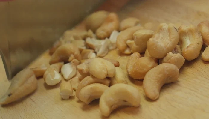 Cashewkerne hacken und Käse reiben.