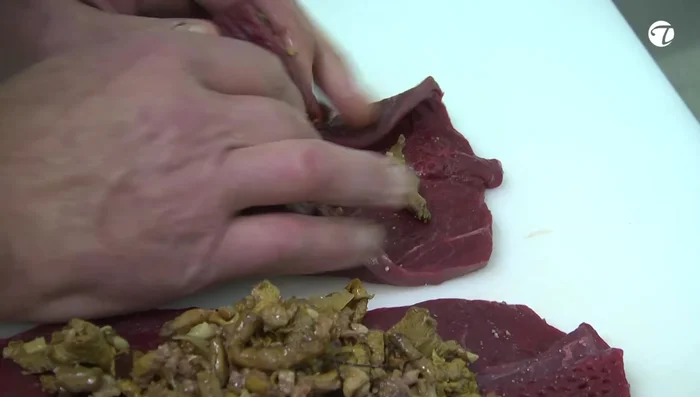 Die Rouladen zusammenrollen und die Seiten einschlagen. Mit Küchengarn oder Klammern und einem Holzstäbchen fixieren.