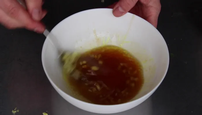 Die Hälfte des Ingwers, die gehackte Knoblauchzehe unterrühren.