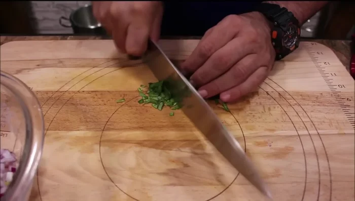 Die gehackten Tomaten, Zwiebeln und Basilikum mit granuliertem Knoblauch, Salz, Pfeffer, Balsamico-Essig und Olivenöl vermischen.