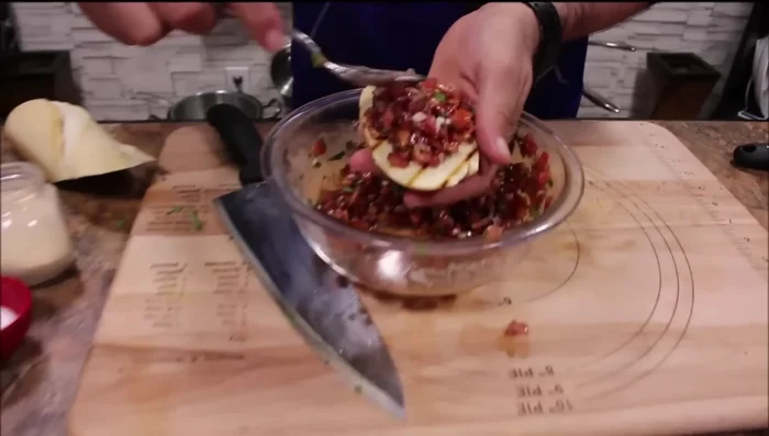 Die Bruschetta-Mischung auf die gegrillten Brotscheiben geben.