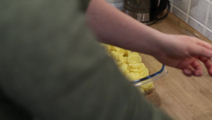 Soße über die Kartoffelscheiben geben und vermengen. (173.599)