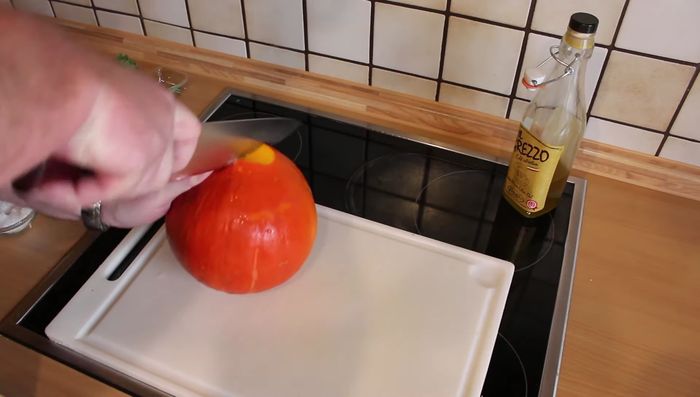 Hokkaido Kürbis halbieren, Kerngehäuse entfernen und in Stücke schneiden.