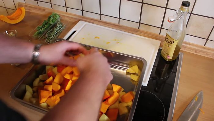 Kartoffeln, Kürbisstücke, Knoblauch, Salz, Pfeffer und Olivenöl vermengen.