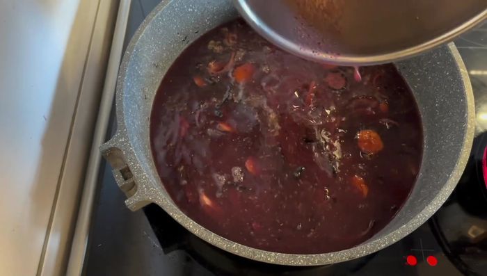 Rotwein in den Bräter geben und mindestens 15 Minuten köcheln lassen. 1 EL Preiselbeeren hinzufügen.