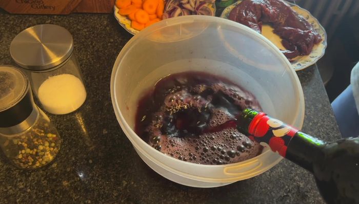 Rotweinsoße vorbereiten: Zwiebeln, Karotten, Thymian, Estragon, Salz und Pfeffer in Rotwein mischen.