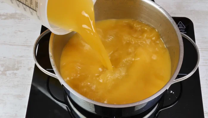 Für die Fruchtschicht Multivitaminsaft, Speisestärke und Zucker in einem Topf vermischen, unter ständigem Rühren aufkochen, bis ein Pudding entsteht. Mindestens 1 Minute weiterköcheln lassen und dann heiß über den Milchpudding verteilen.