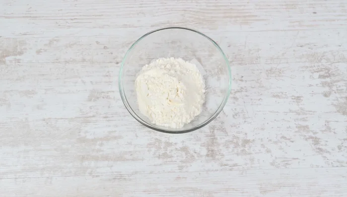 Für den Milchpudding Milch, Zucker, Vanillezucker, Speisestärke und Butter in einem Topf vermischen, glatt rühren und unter ständigem Rühren zum Kochen bringen, bis ein Pudding entsteht. Mindestens 1 Minute weiterköcheln lassen, um den mehligen Geschmack zu vermeiden. Auf niedrige Hitze schalten, um Anbrennen zu verhindern.