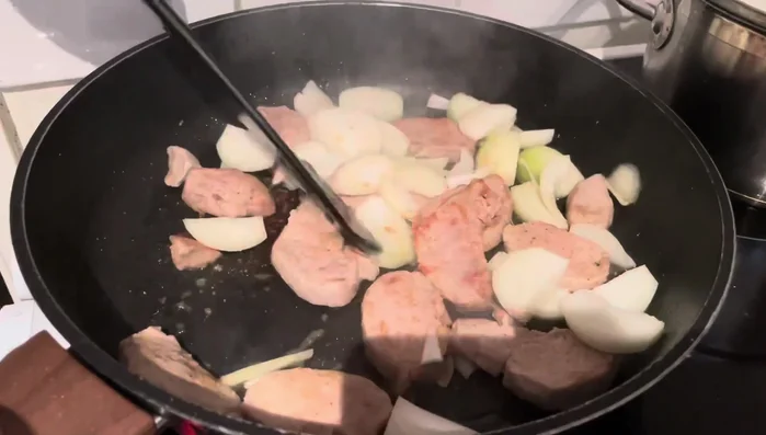 Zwiebeln in die Pfanne geben und mitbraten.