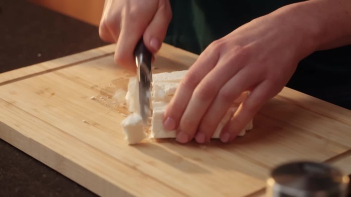 TK-Spinat antauen lassen (in einem Sieb mit Schale darunter). Zwiebel und Knoblauch schälen und klein schneiden. Auflaufform vorbereiten.
