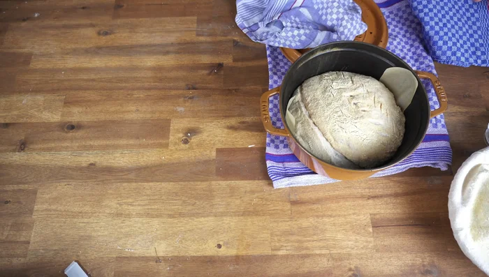 Backofen auf 250°C vorheizen. Brot in einen gusseisernen Topf geben und 20 Minuten backen. Danach Deckel abnehmen und weitere 40 Minuten bei 200°C backen (435.15).