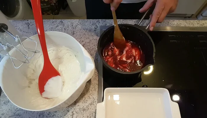 Einen Teil der Quarkmasse in die warme Himbeermasse geben, verrühren und wieder zum Quark geben. Alles gut verrühren.