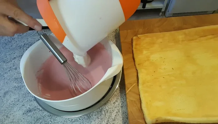 Biskuit ausrollen. Wenn die Masse genug geliert hat, Sahne unterheben.