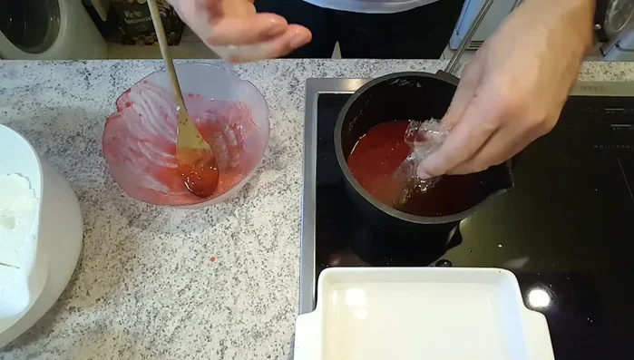 Ausgedrückte Gelatine in das warme Himbeermus geben, umrühren bis sie sich auflöst.