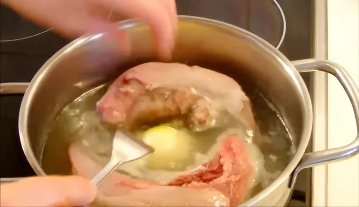 Zwiebel und Knoblauch halbieren und in den Topf geben.