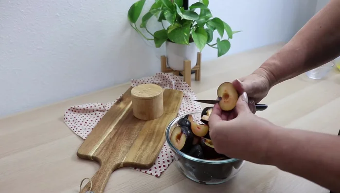 Pflaumen waschen, Stiele entfernen und halbieren. Jede Hälfte in 3-4 Stücke schneiden. Äpfel schälen, Kerngehäuse entfernen und in dünne Scheiben schneiden.