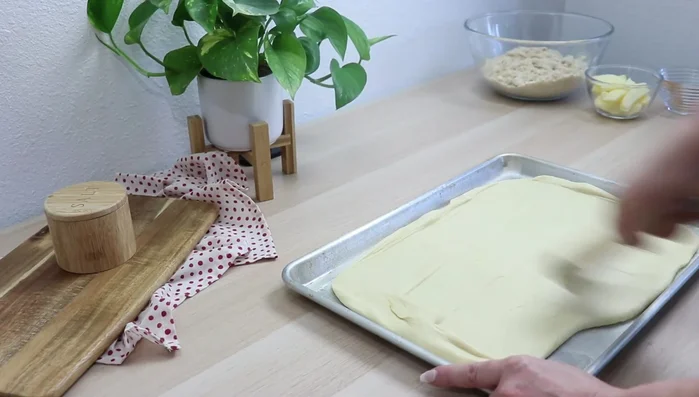 Backblech einfetten und mehlen. Teig ausrollen, Apfel- und Pflaumenscheiben darauf verteilen (leicht überlappend). Mit Zimt bestreuen (optional).